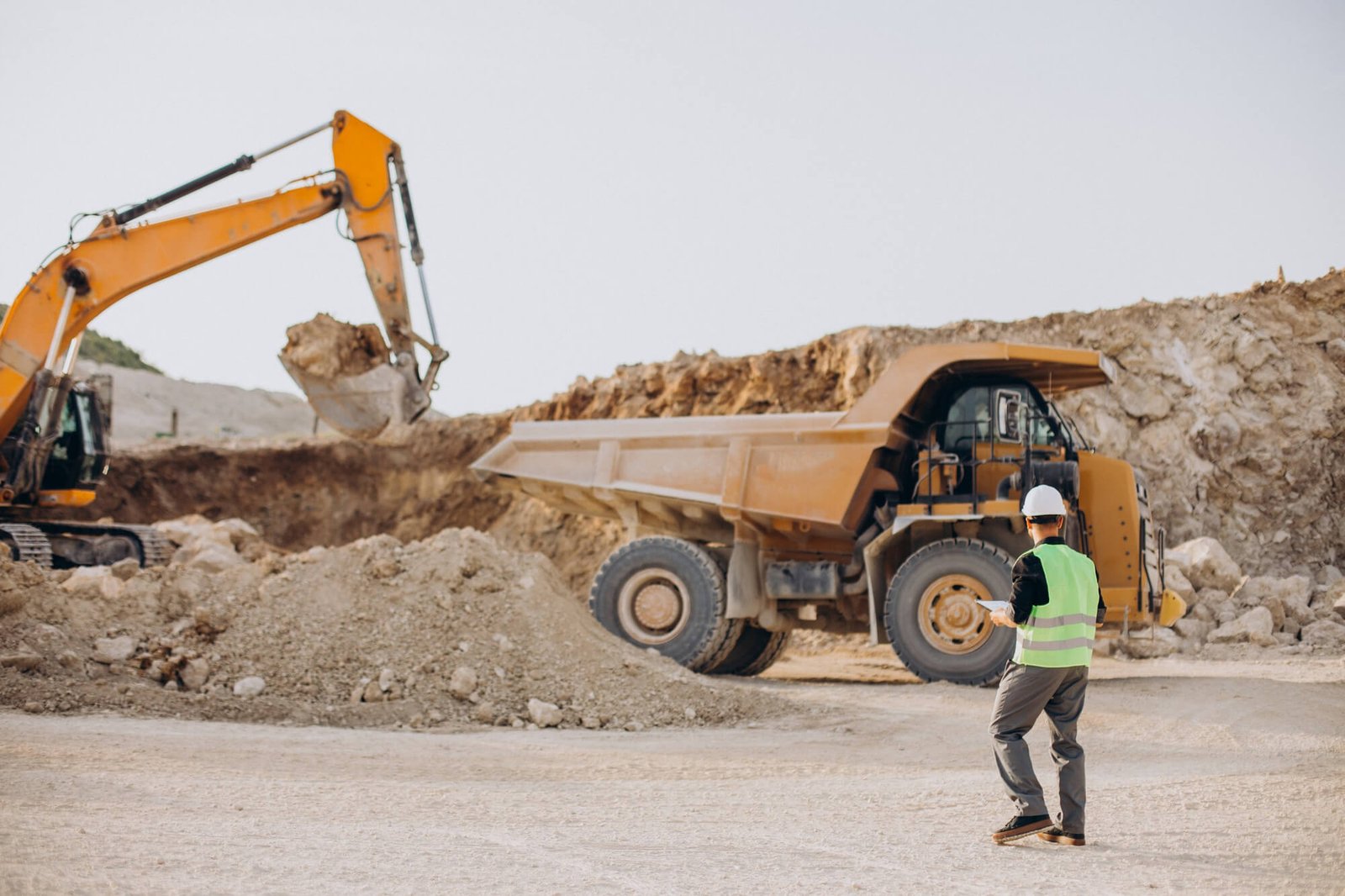 Two construction workers estimating exterior improvements in front of a dump truck.